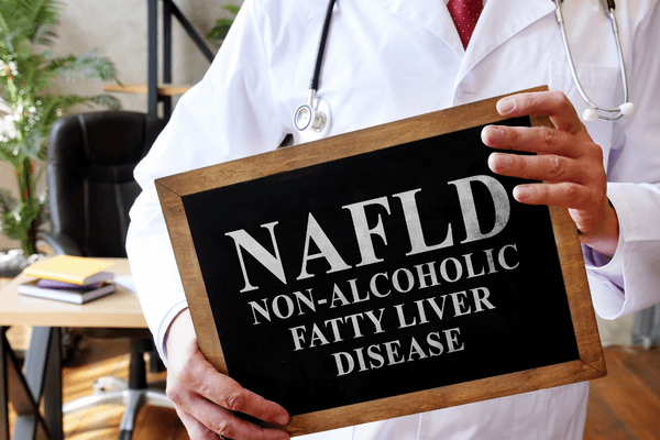 Zdravnik drži tablo z napisom »NAFLD«.