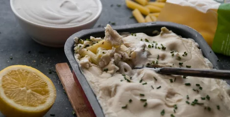 Zapečene testenine v pekaču na črni mizi.