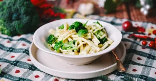 Tahini pasta z limono in brokolijem na krožniku s testenino